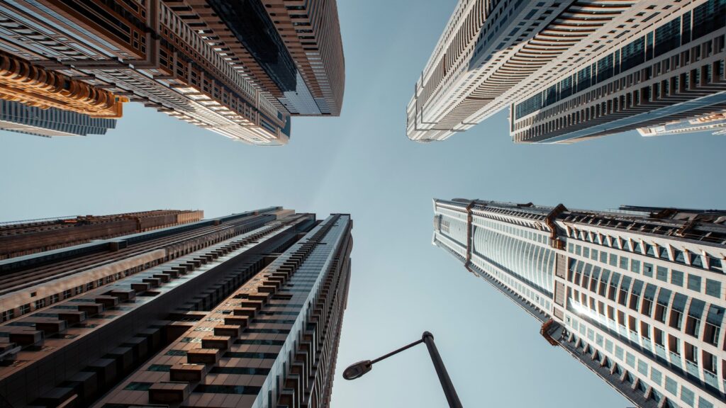 Low-angle view of modern high-rise residential towers against a clear blue sky in Dubai, representing Azizi Riviera 18's Meydan setting
