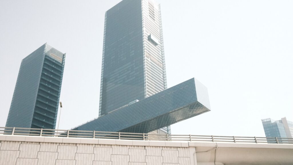 Low-angle view of sleek modern glass high-rise towers against a clear sky in Dubai, representing Azizi Riviera 41's Meydan setting
