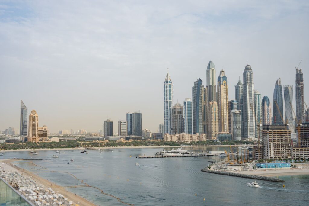 Aerial view of JBR's beachfront towers, sandy beach and marina entrance channel with yachts and waterfront construction cranes, near Bahar 4, JBR