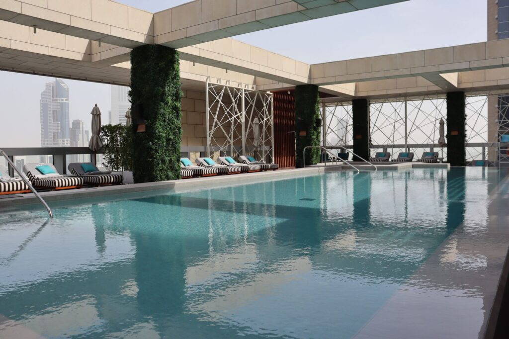 Rooftop swimming pool with cabana loungers near Binghatti Azure, JVC, Dubai