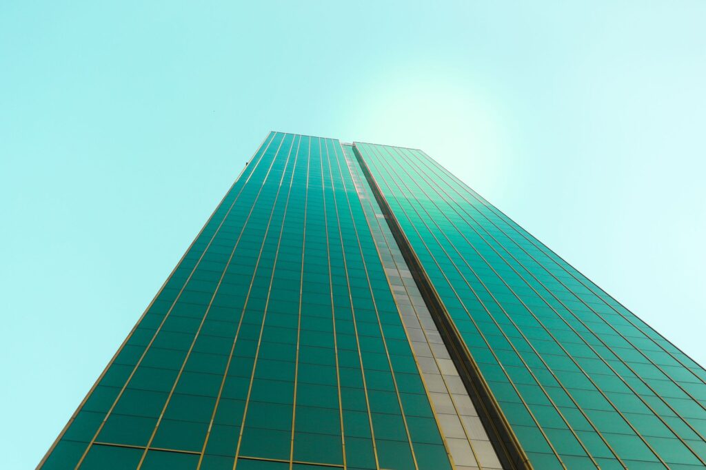Upward view of a glass Dubai high-rise tower against a clear sky