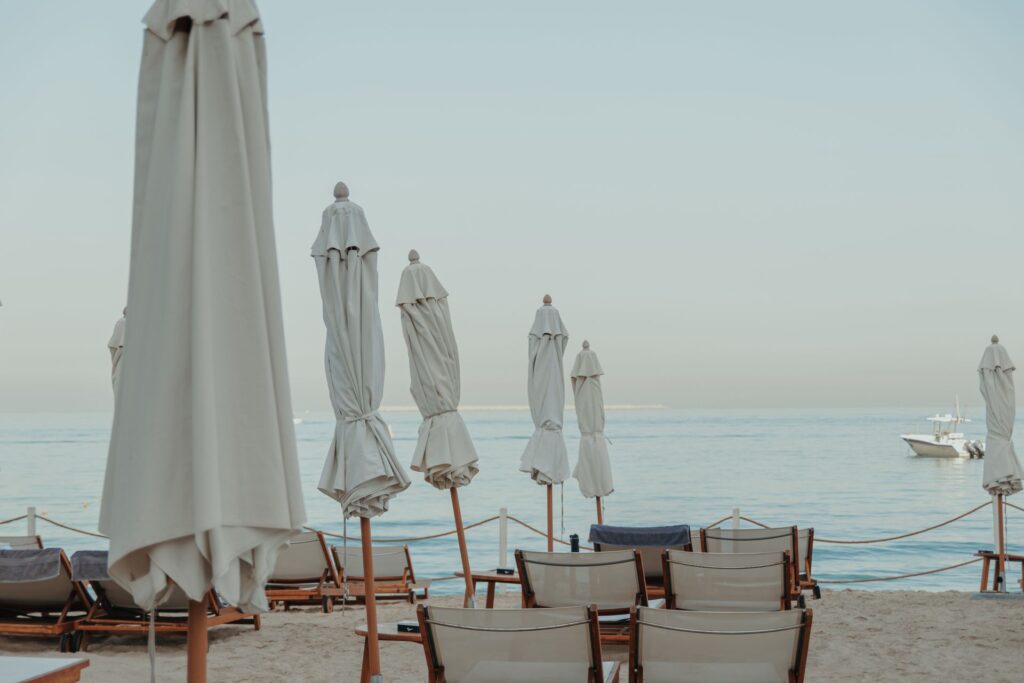 Empty beach loungers and closed umbrellas on a quiet Dubai beach at sunrise