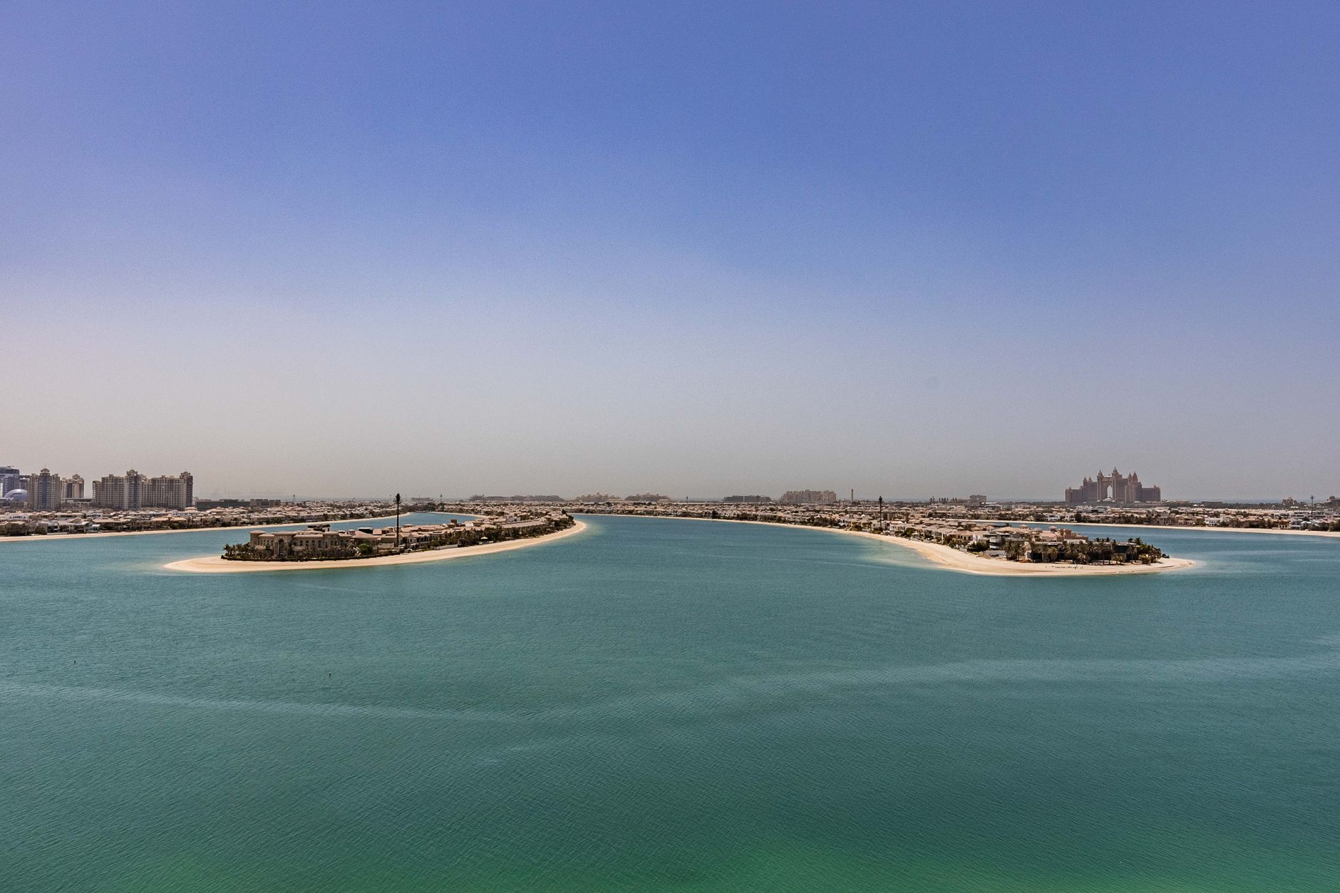Aerial view of Palm Jumeirah frond tips with villa communities and turquoise water, Dubai