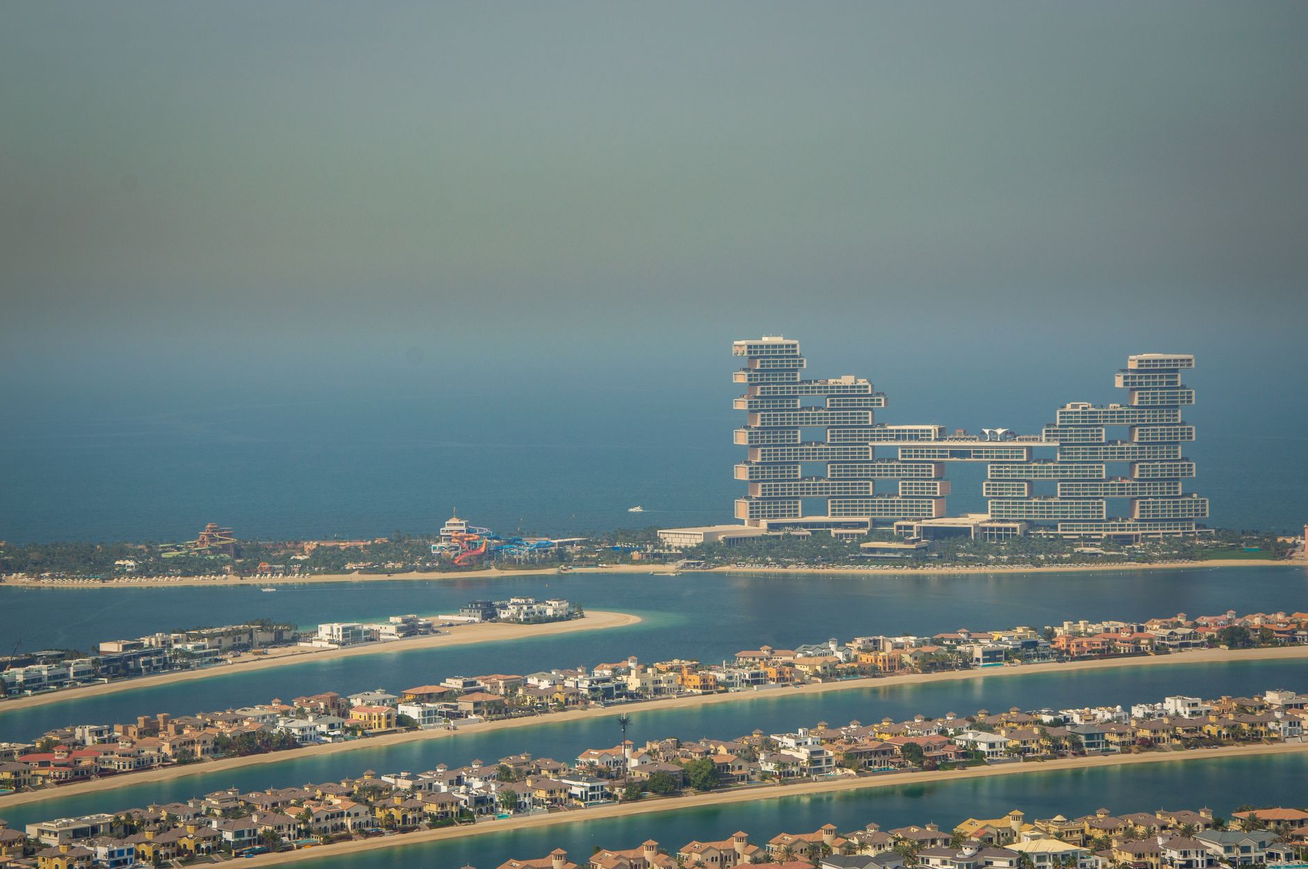 Aerial view of Palm Jumeirah frond villa rows with Atlantis The Royal in the background, Dubai