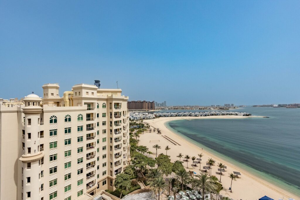 Aerial view of Palm Jumeirah beach and villa rooftops along a frond, Dubai