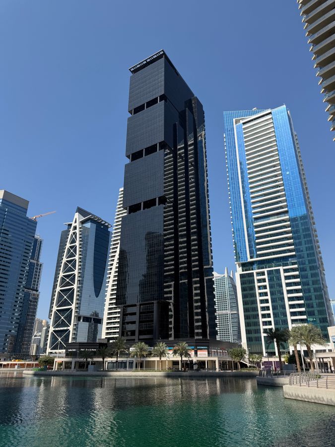 Modern skyscrapers of Jumeirah Lake Towers in Dubai reflecting in the lake water, representing Goldcrest Views 1 in Cluster V of JLT