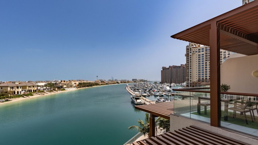 Marina view on Palm Jumeirah with a mid-rise apartment building and yachts along the waterfront