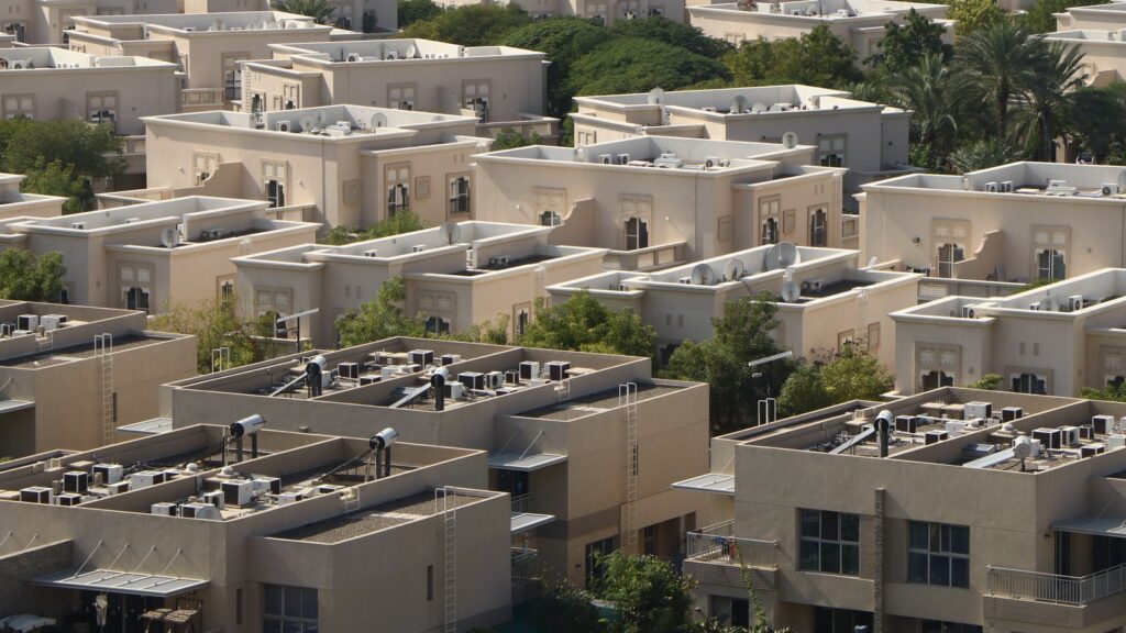 Aerial view of a residential community in Dubai with Gulf-style architectural detailing and palm trees