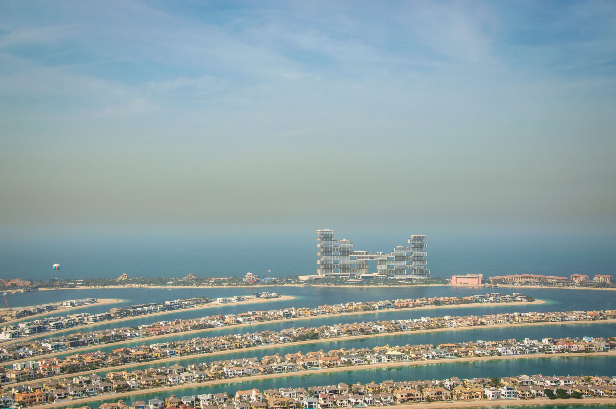 Aerial view of Palm Jumeirah's fronds with villa rooftops and private pools, Atlantis The Royal visible on the crescent, Dubai