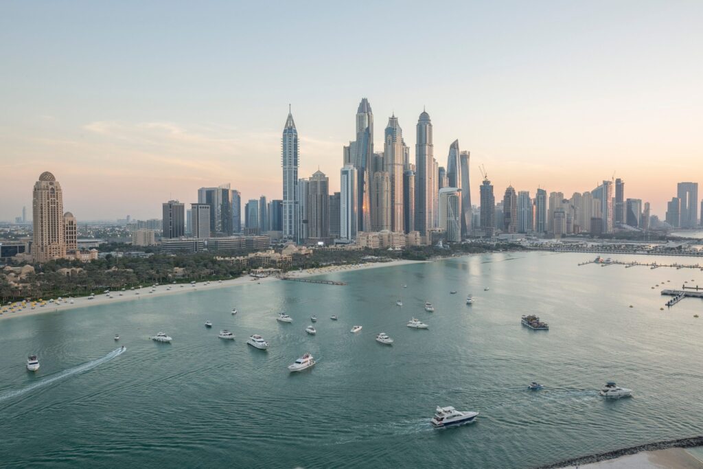 Aerial view of Palm Jumeirah waterfront towers and marina at sunset with boats on the water