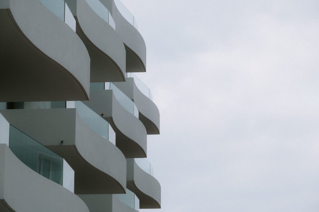 A striking view of modern curved balconies with a minimalistic design against a cloudy sky