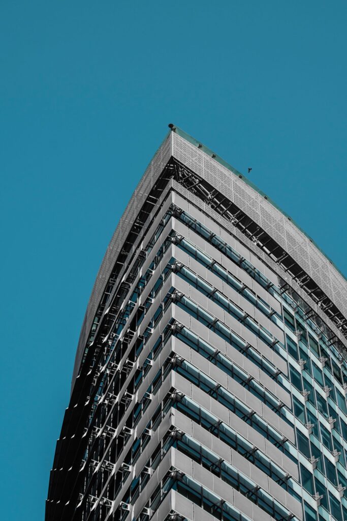 Modern high-rise apartment tower exterior against blue sky in Dubai, representing Bloom Towers C in Jumeirah Village Circle