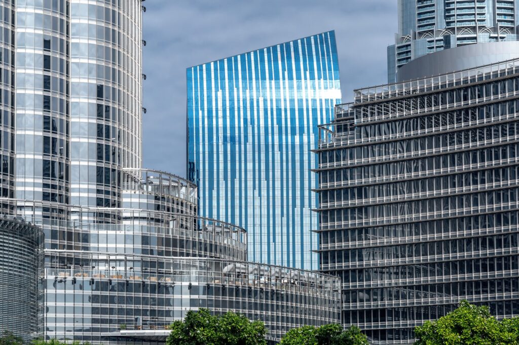 Close-up of modern glass skyscrapers in Dubai against a partly cloudy sky