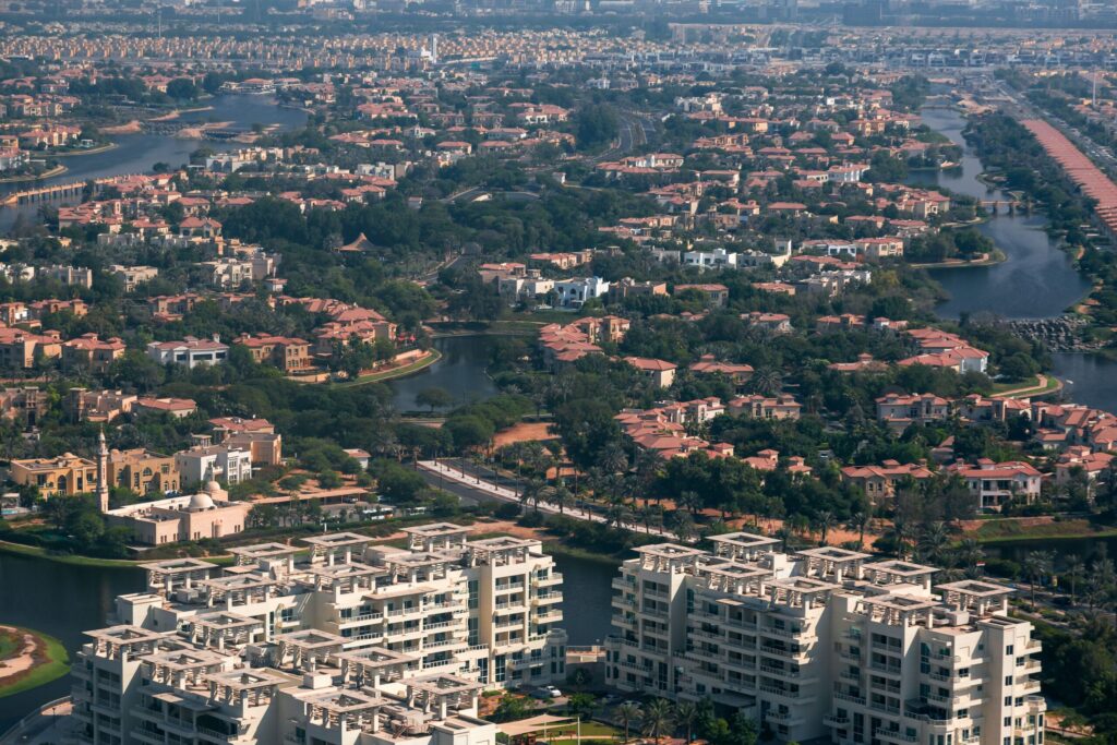 Aerial view of a low-rise villa community with green spaces in Dubailand, Dubai