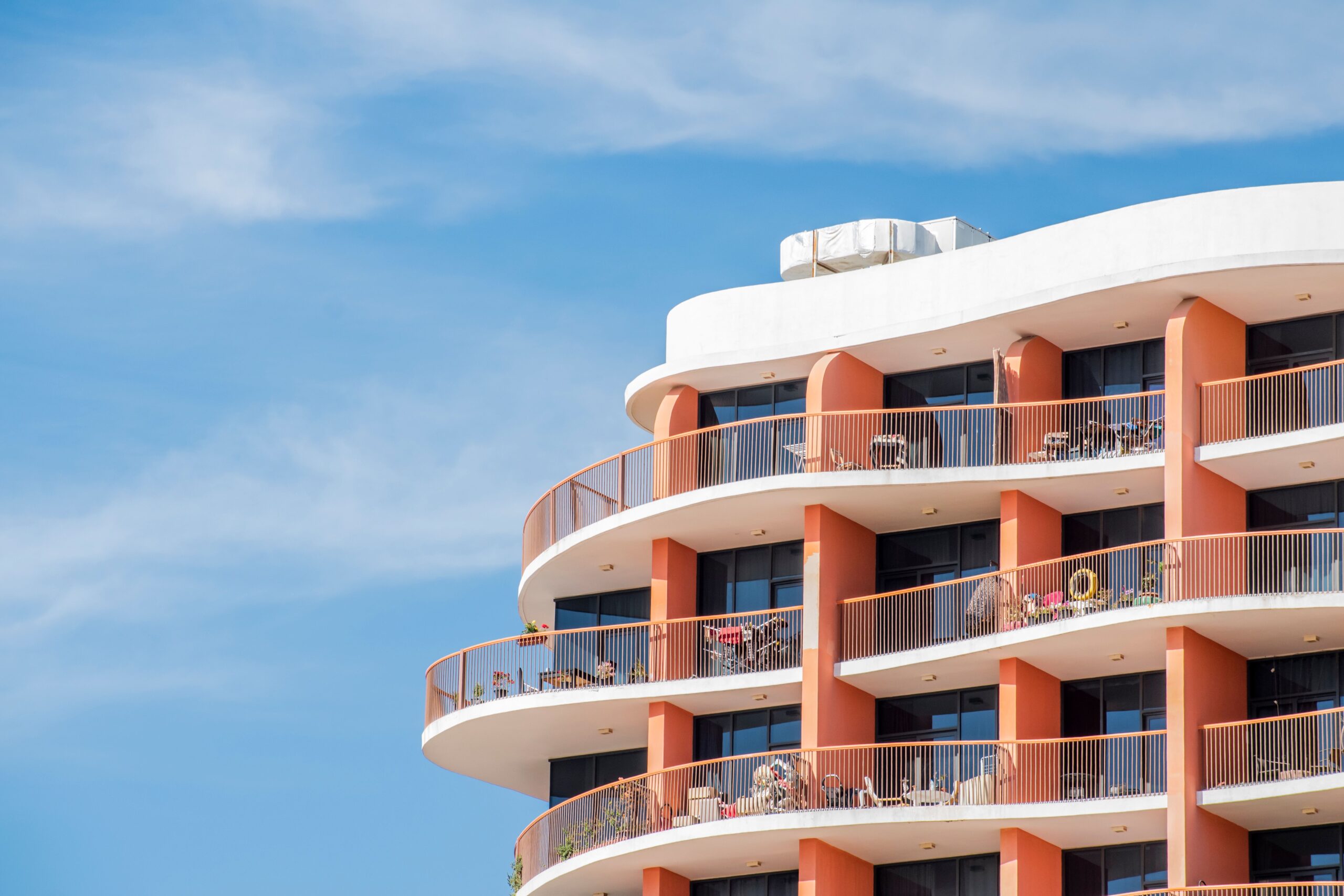 Curved-balcony cream and terracotta mid-rise residential building near Sannat Residency, International City