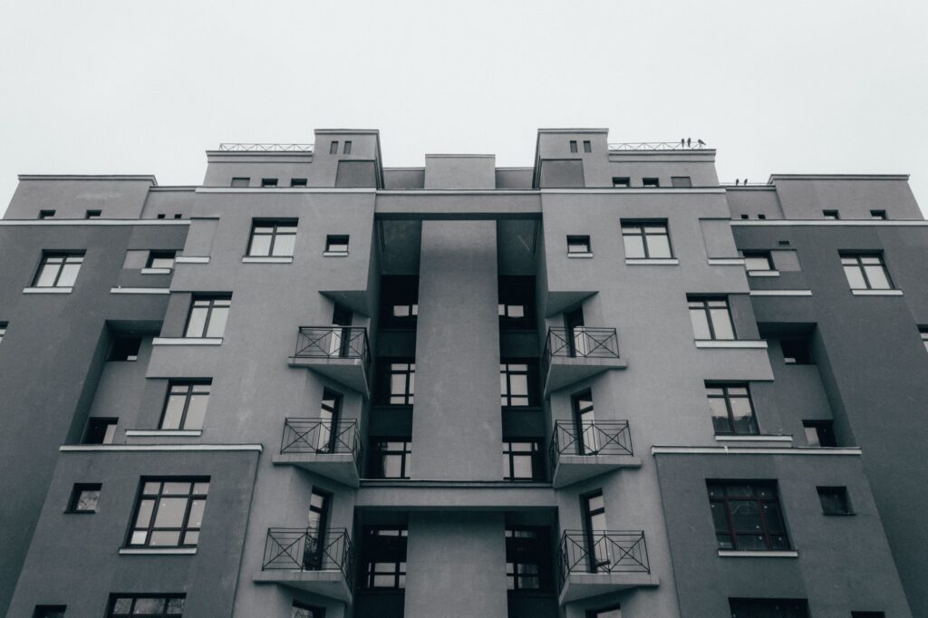 Minimalist grey concrete apartment facade with a symmetrical grid of windows