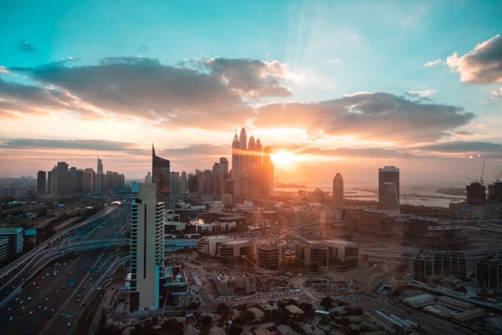 Aerial view of the Dubai skyline at sunset with dramatic clouds over a cluster of high-rise towers