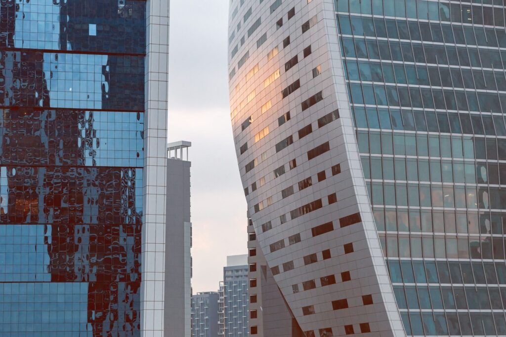Abstract close-up of glass and stone tower facades in Dubai with a warm sunset reflection