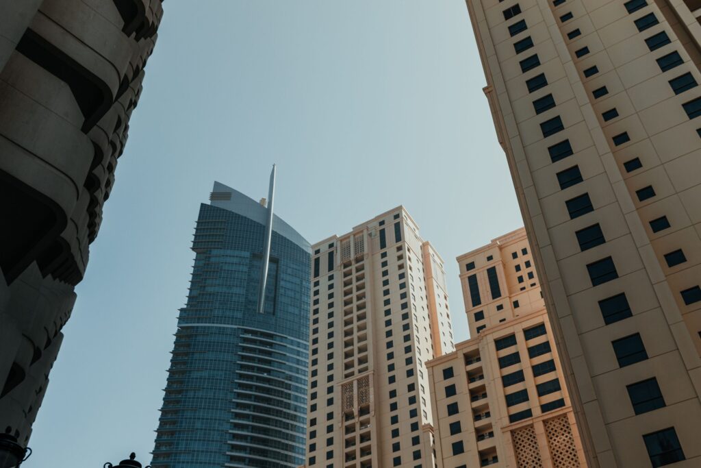 Modern glass skyscrapers in Dubai's skyline with a residential tower in the foreground