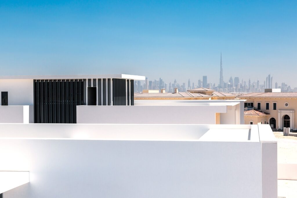 White modern building rooftop with the Dubai skyline visible in the hazy background