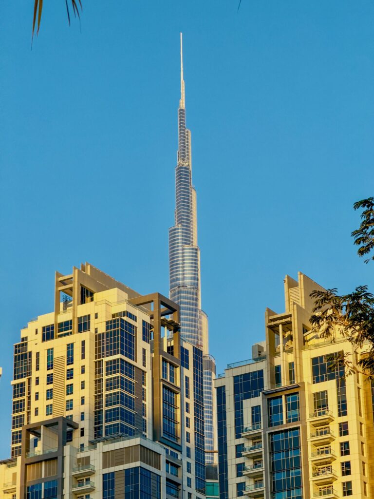Burj Khalifa towering over Downtown Dubai residential buildings under a clear blue sky
