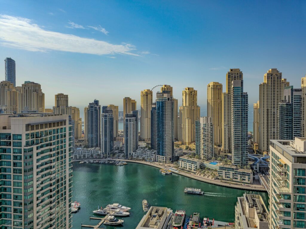 Elevated aerial view of the Dubai Marina lagoon and promenade with Ain Dubai visible in the distance