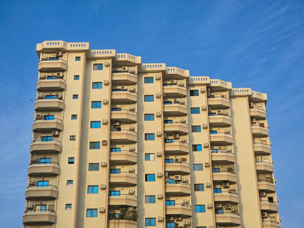 Modern cream-colored residential building against a deep blue sky in Dubai