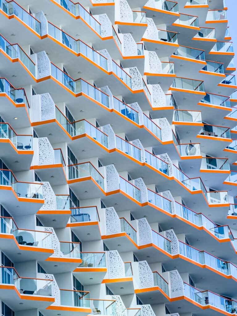 Modern high-rise apartment building facade with geometric balconies in Dubai, representative of Jumeirah Garden City's residential architecture