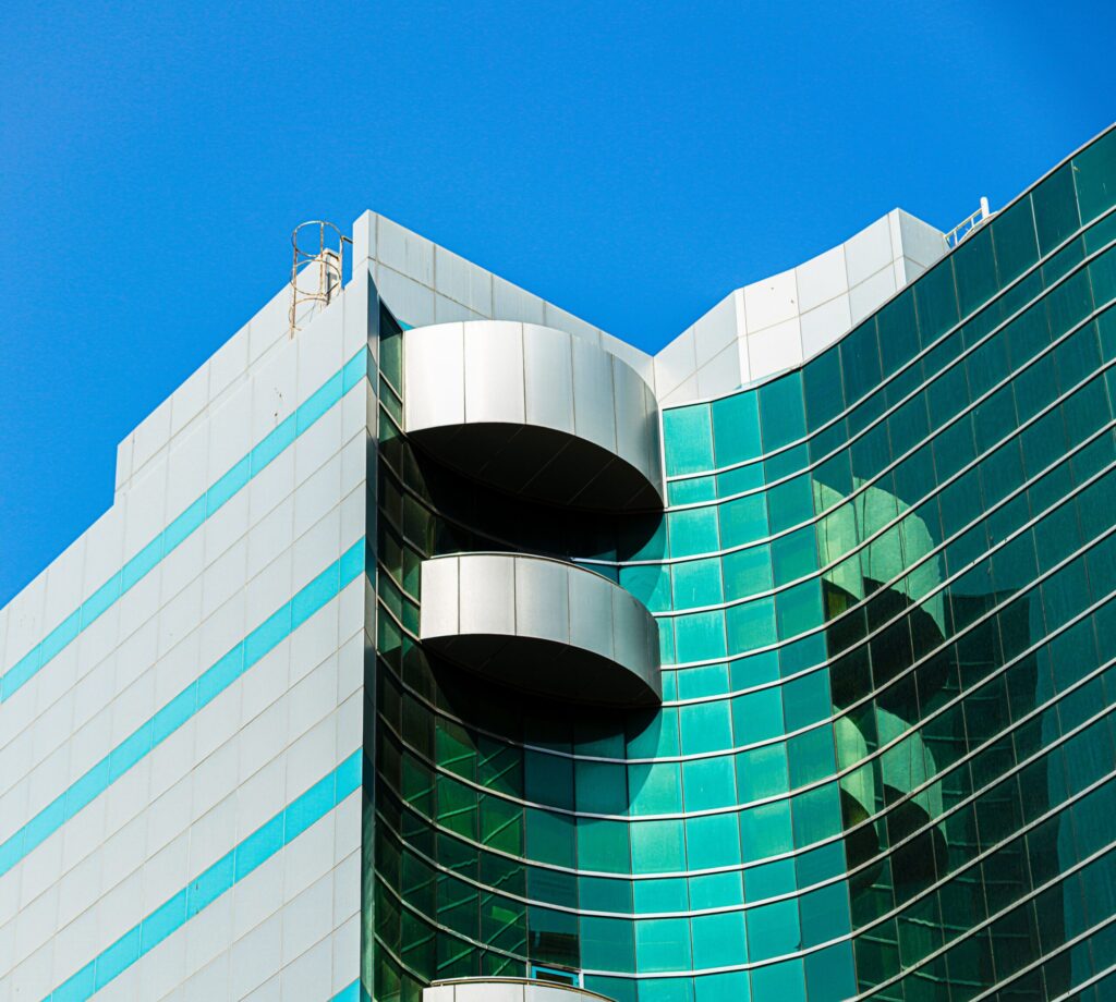 Teal and white curved glass tower facade in Dubai Marina near Marina Wharf