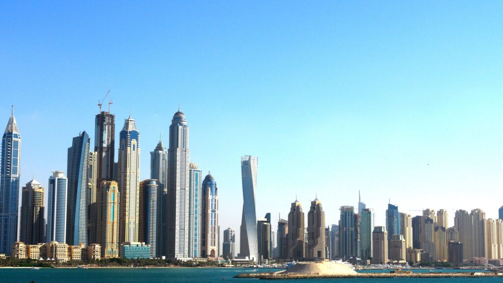 Modern high-rise residential towers along Dubai's waterfront skyline under a clear blue sky