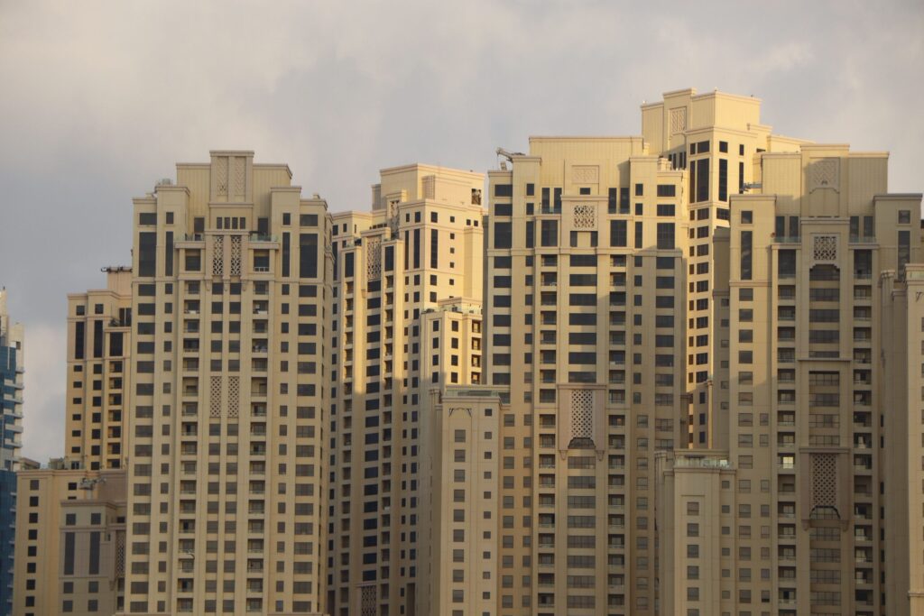 Ornate cream and beige high-rise residential towers at golden hour in Dubai