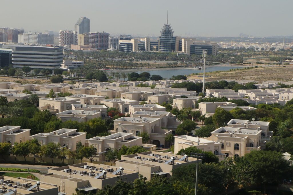 Aerial view of Mudon villa community in Dubailand with lake and Dubai skyline in the background