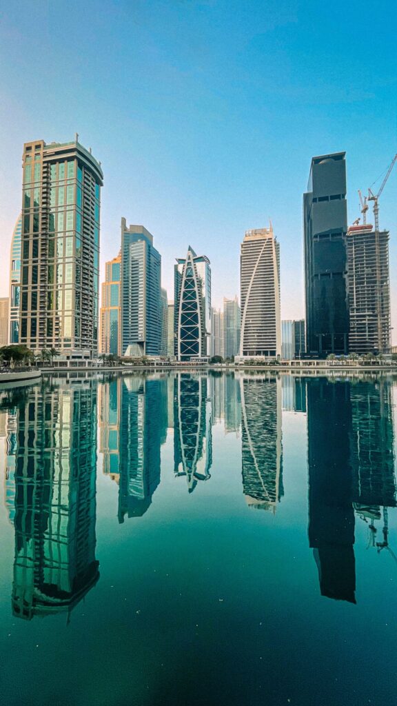 Business Bay Dubai canal skyline with glass high-rise towers reflected in calm water