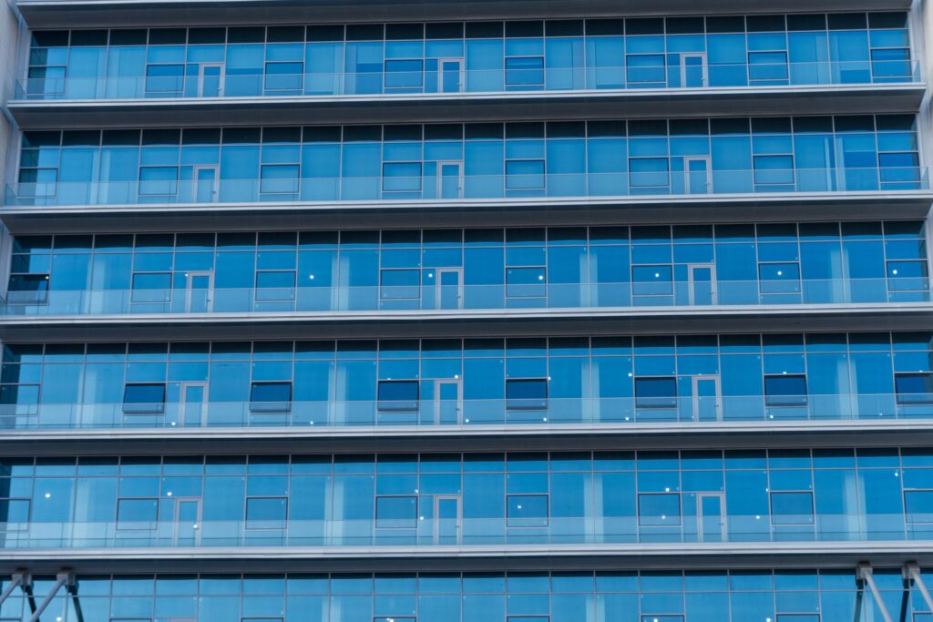 Blue-glass residential tower facade with repeating balcony grid, Downtown Dubai