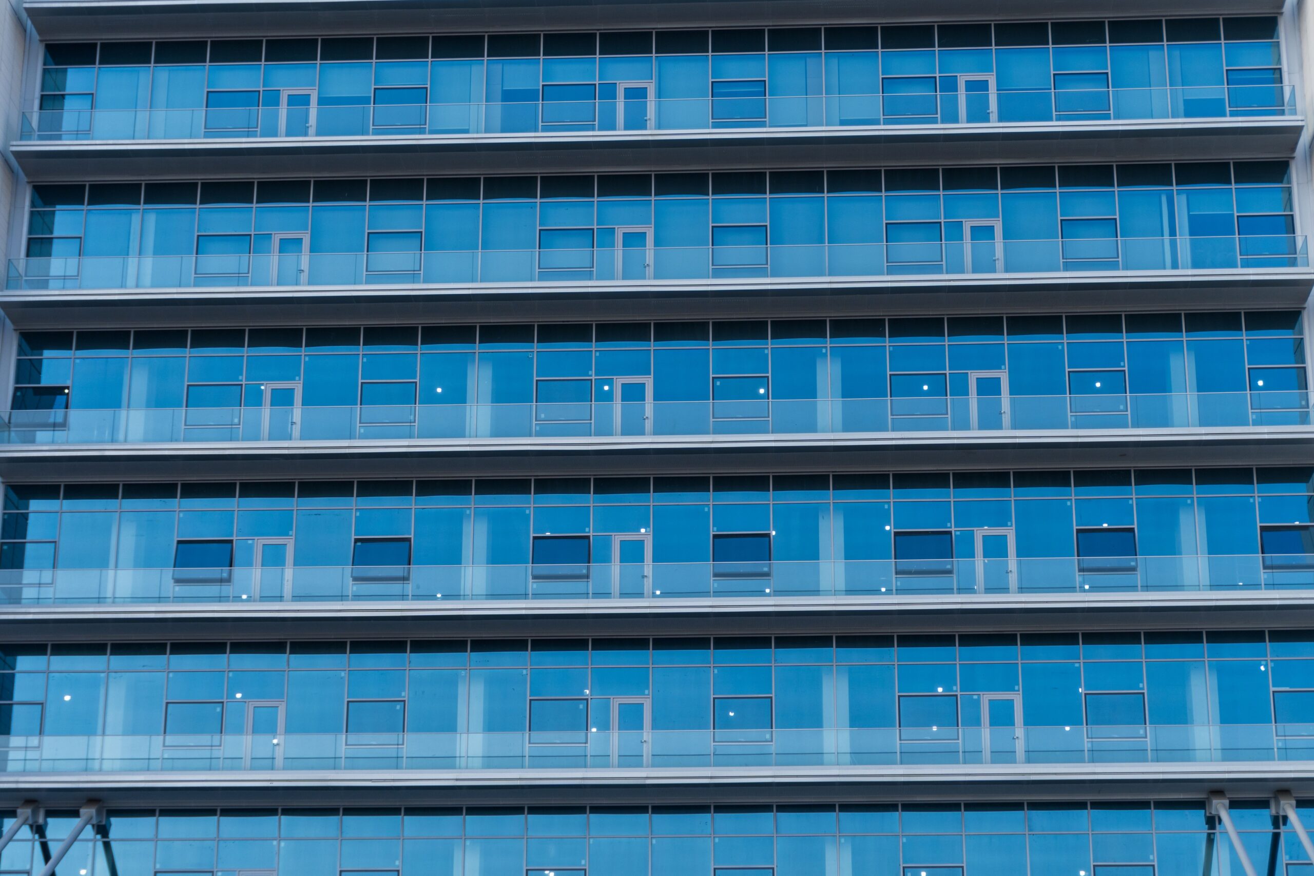 Blue-glass residential tower facade with repeating balcony grid, Downtown Dubai