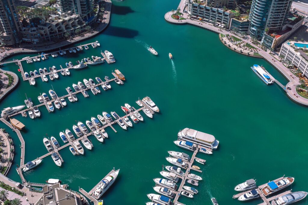 Straight-down aerial view of Dubai Marina's waterway packed with docked yachts on turquoise water