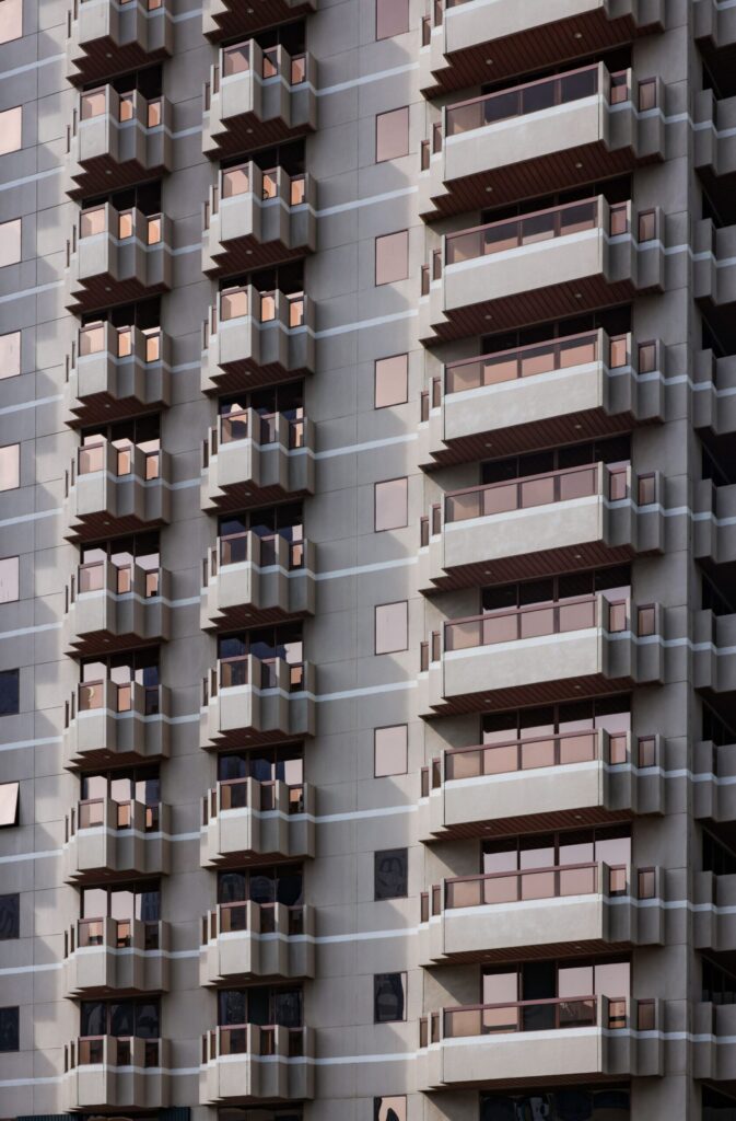 Modern cream and blue glass apartment building facade in Dubai against a clear blue sky