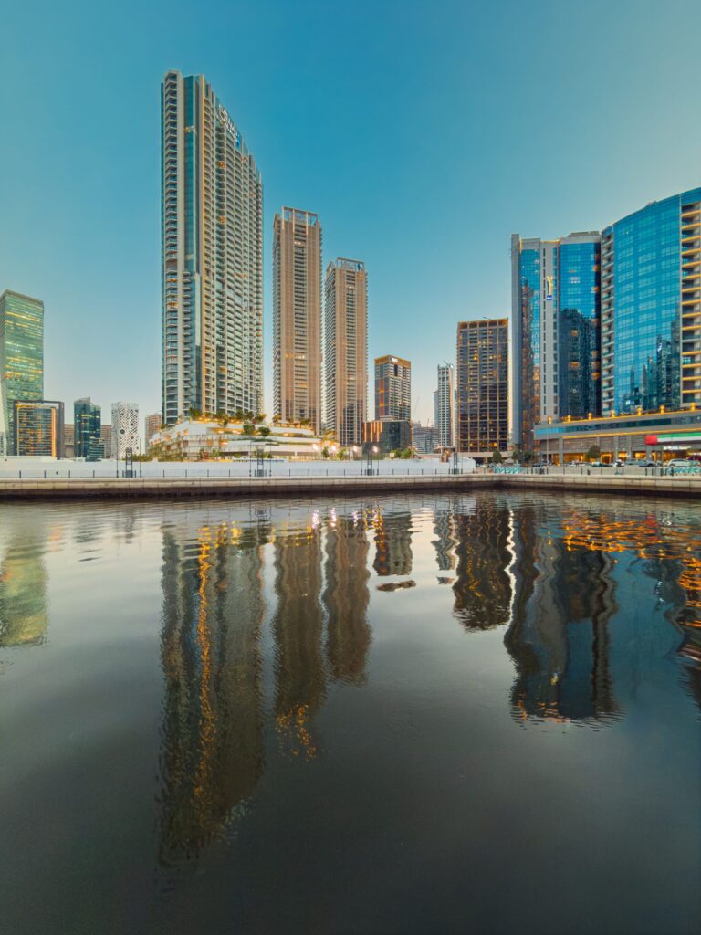 Skyscrapers reflecting in a Dubai canal at dusk