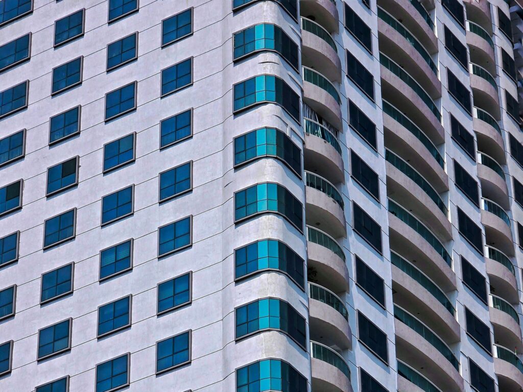 Close-up of a curved-balcony glass residential tower facade in Dubai Marina