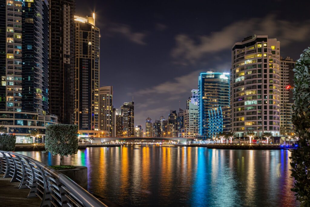 Illuminated Dubai Marina canal at night with towers reflected in the water