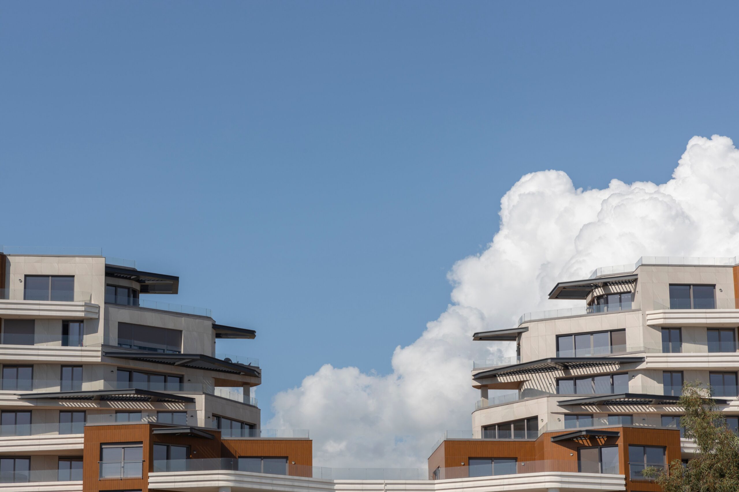 Modern Dubai apartment tower rooflines against a blue sky, representative of the Muhaisnah skyline near Madinat Badr.