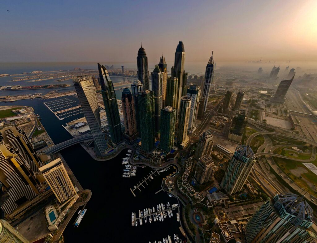 Golden-hour aerial view over the Dubai Marina towers and yacht basin