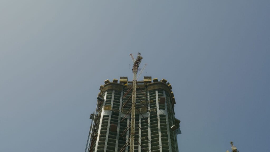 Tower under construction with crane against clear sky, Arjan, Dubai