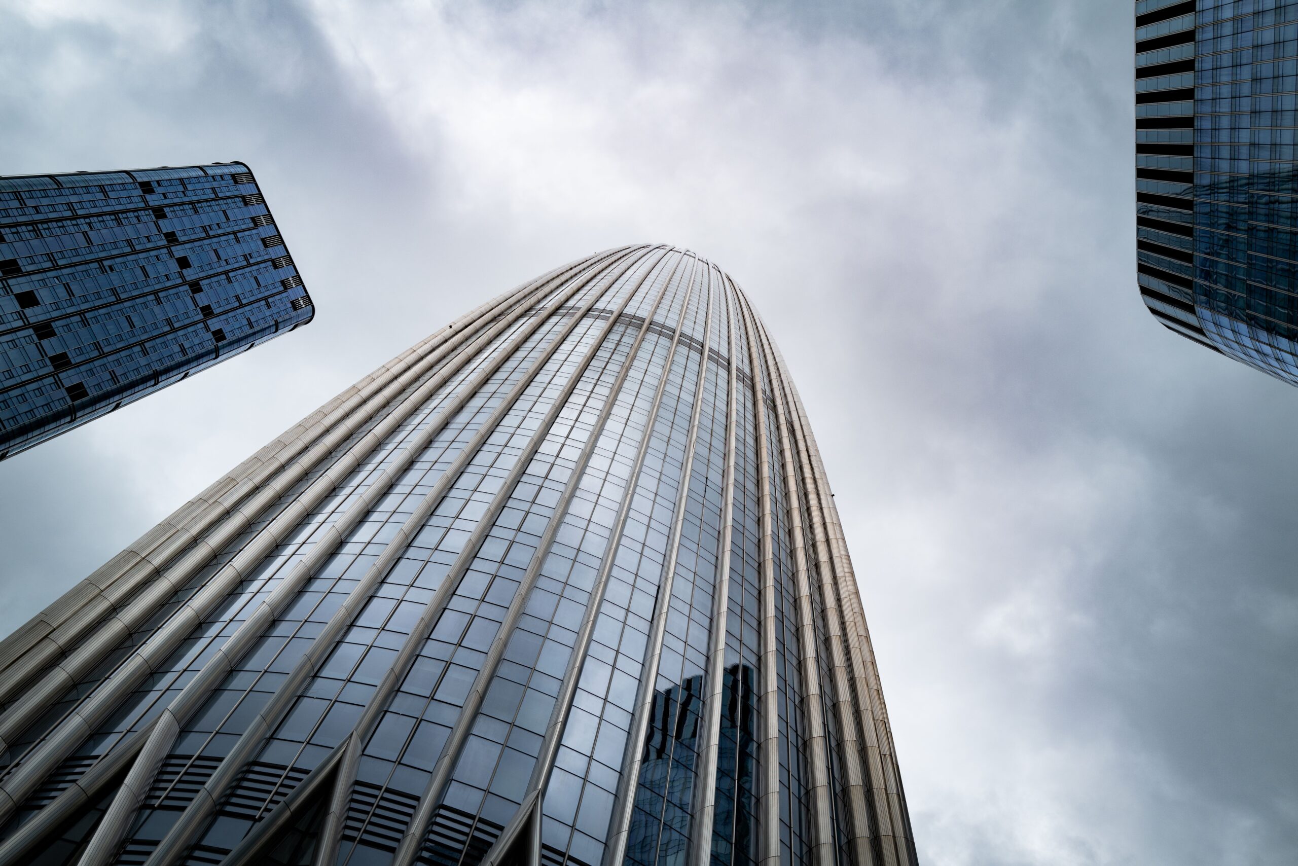 Low-angle view of a fluted glass Dubai Marina tower facade near Marina Wharf II