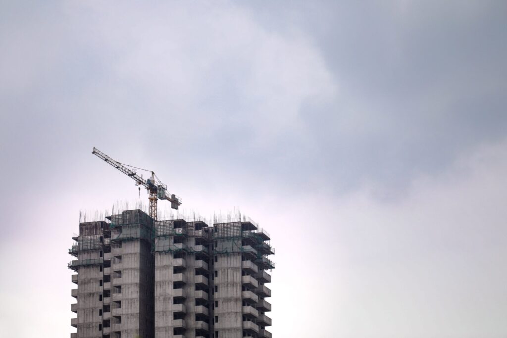 High-rise tower under construction with exposed formwork and crane, Meydan Horizon, Dubai