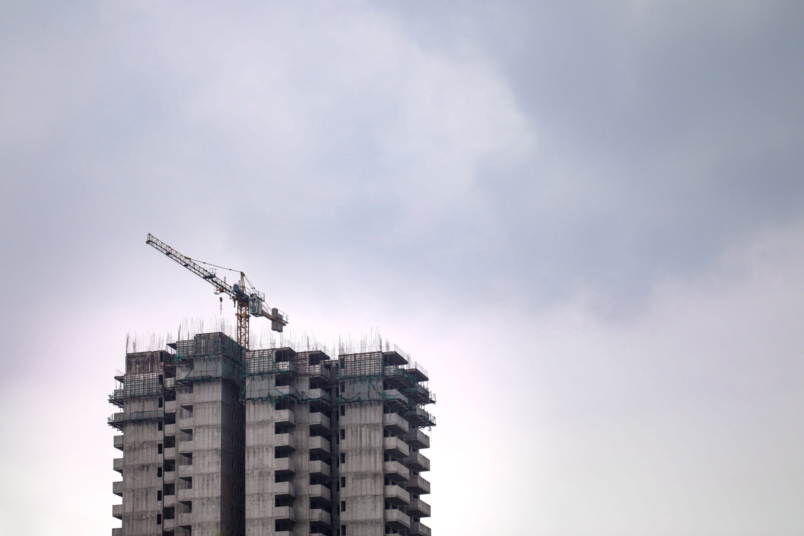 High-rise tower under construction with exposed formwork and crane, Meydan Horizon, Dubai