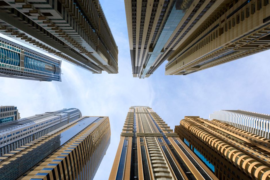 Low-angle view of Dubai high-rise apartment towers against a clear sky