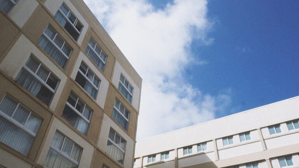 Low-angle view of a modern apartment building facade against a clear blue sky in Dubai