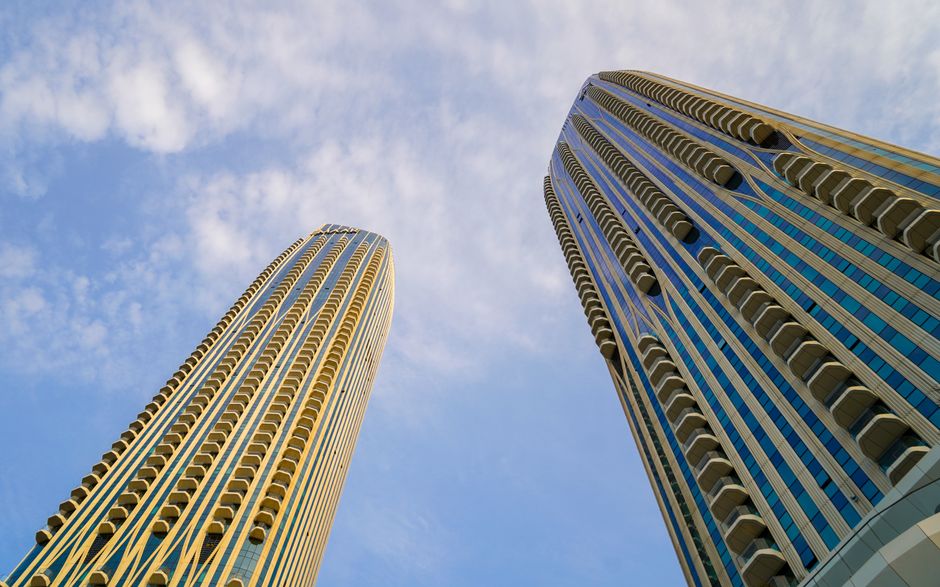 Curved-balcony Dubai high-rise towers against a clear sky