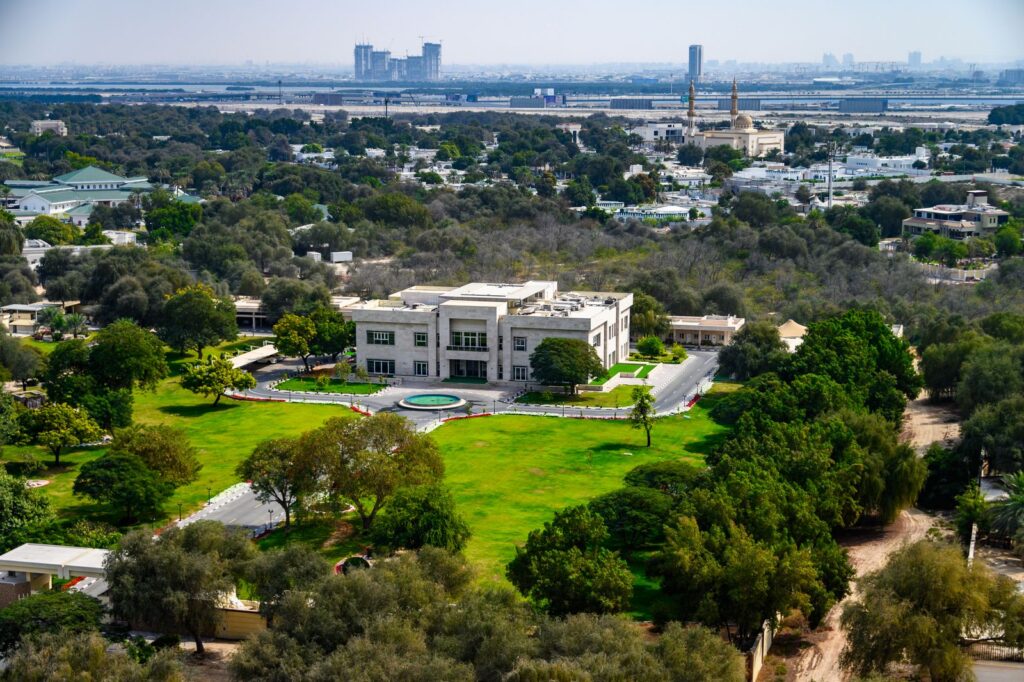 Aerial view of a lush green Dubai residential landscape, representative of Sobha Hartland's lagoon and parkland setting